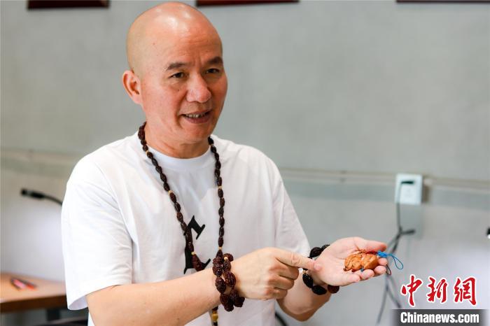 金华核雕传承人以橄榄核雕刻亚运吉祥物 作品将